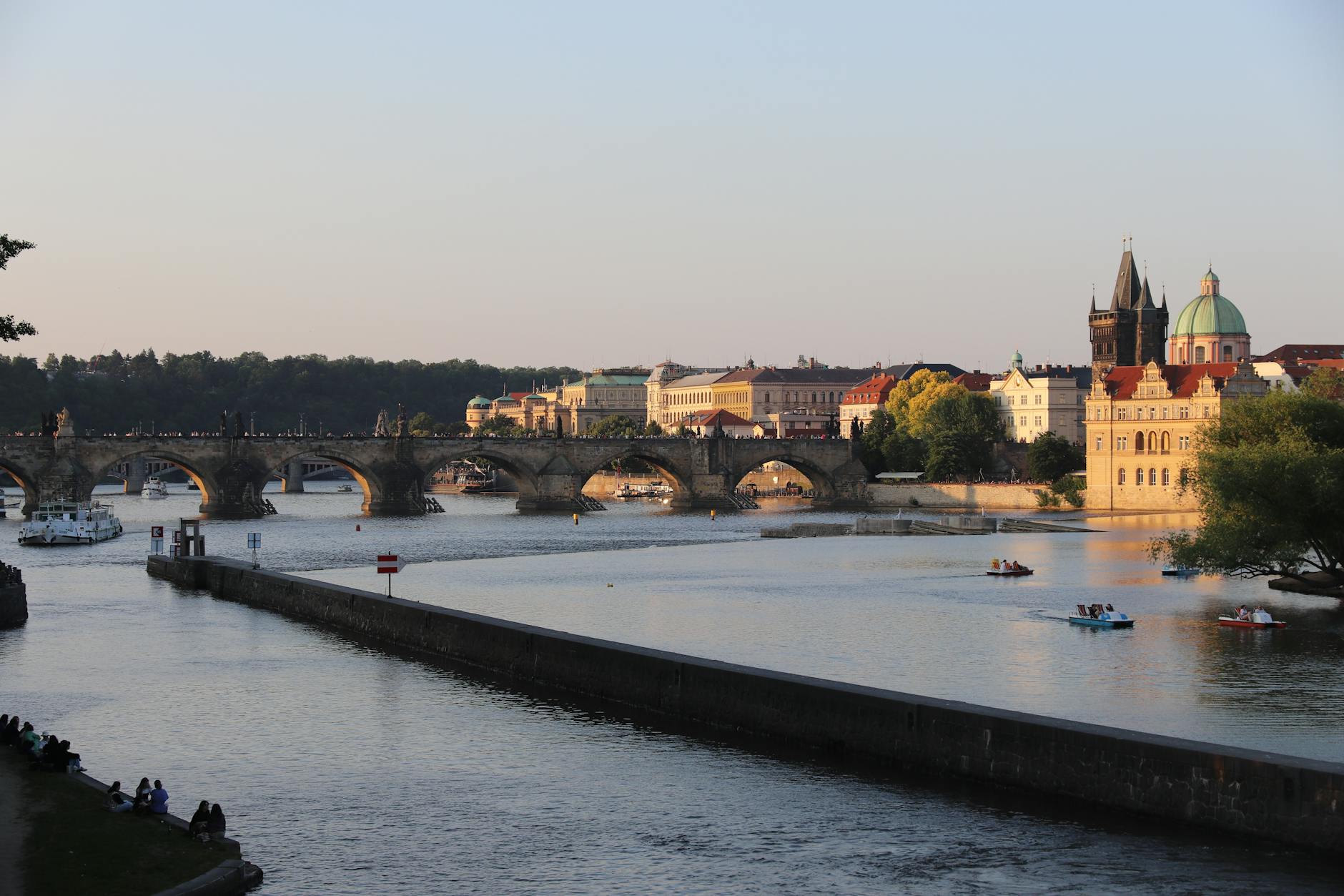 Charles Bridge at sunset with historical statues and river