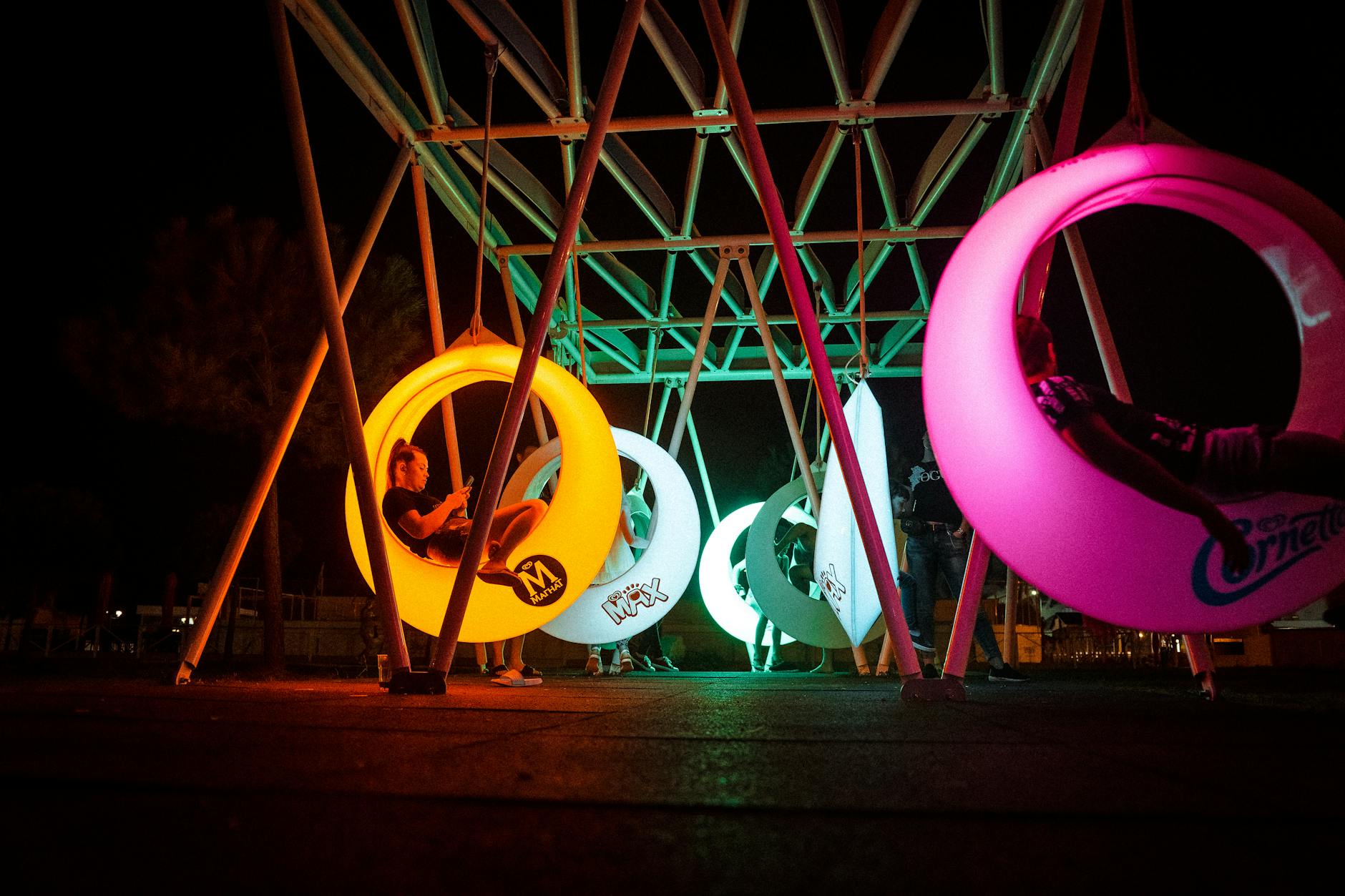 city park illuminated at night with people enjoying