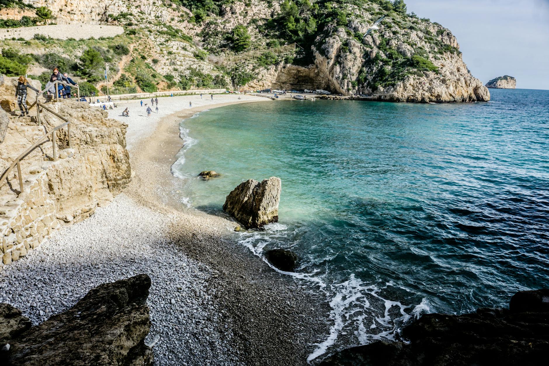 hiking trail leading to a beach with clear blue waters