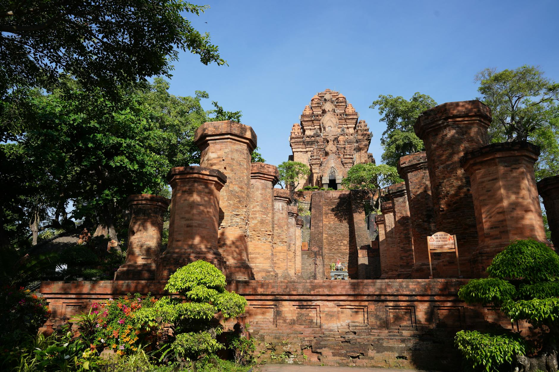 Ancient monument in a forest, surrounded by trees and vines