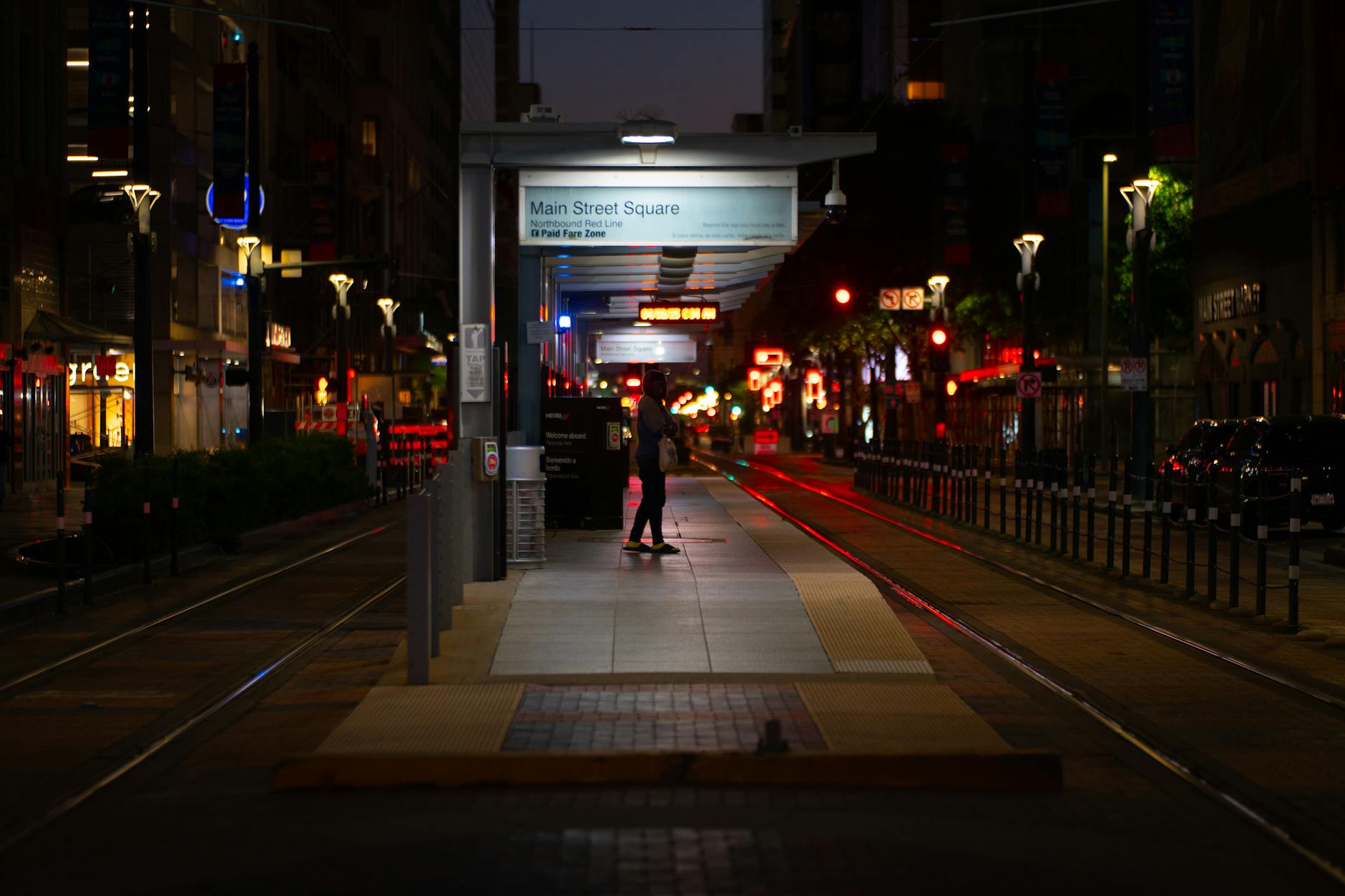 Main Street illuminated at night with colorful lights and empty sidewalks