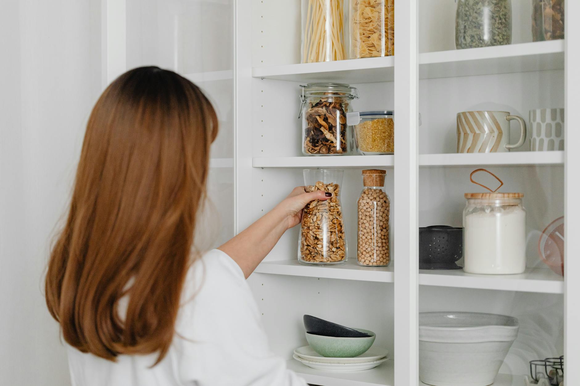 organized pantry shelves with jars and containers