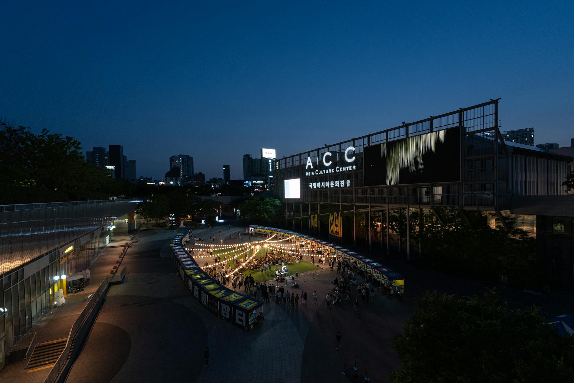 town square illuminated at night with community gathering